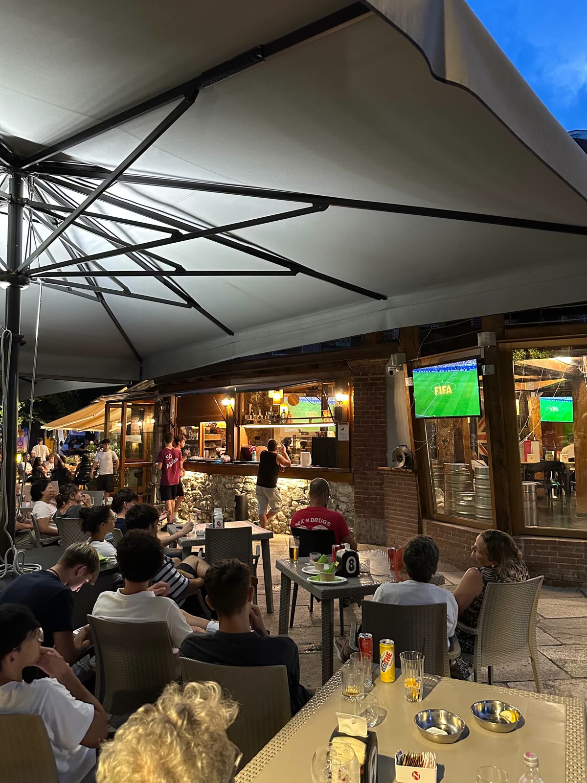 Serata affollata sotto gli ombrelloni del dehors, con la partita sugli schermi